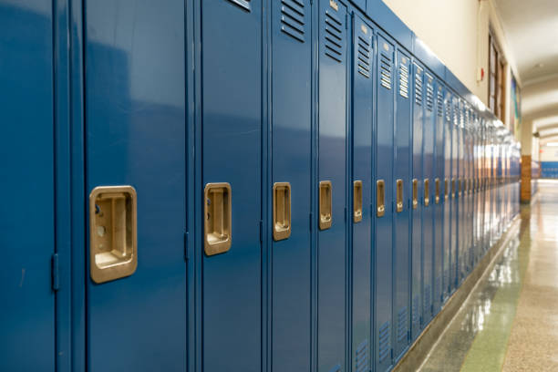 foto eines blauen metallschließfachs entlang eines unscheinbaren flurs in einer typischen us-amerikanischen high school. keine identifizierbaren informationen enthalten und niemand in der halle. - schulgebäude stock-fotos und bilder