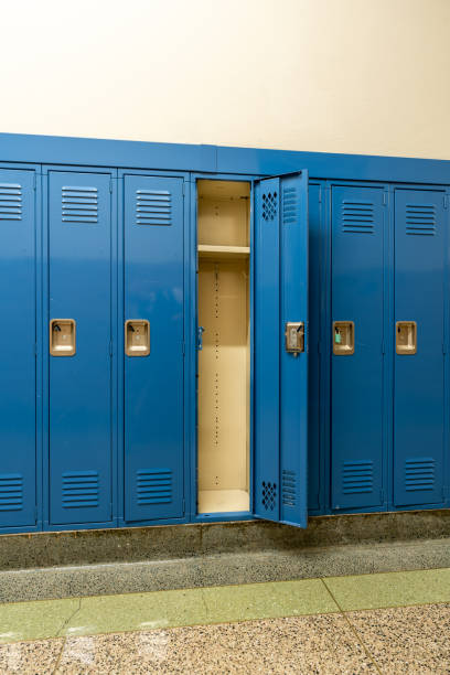 istock Single open empty blue metal locker along a nondescript hallway in a typical US High School.  No identifiable information included and nobody in the hall. 1439804077
