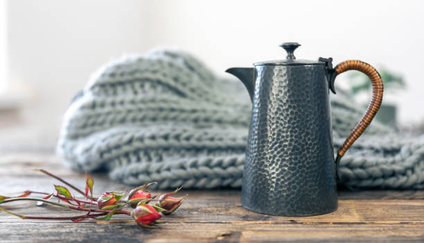 istock Textured gray teapot and knitted element on a blurred background. 1439805228