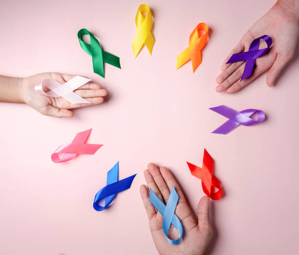 Hands of people holding colorful ribbons on pink background, cancer awareness, World cancer day, National cancer survivor day, world autism, supported living and illness, Prostate awareness concept. manos de personas sosteniendo cintas coloridas sobre fondo rosa, conciencia sobre el cáncer, día mundial contra el cáncer, día nacional del sobreviviente de cáncer, autismo mundial, vida apoyada y enfermedad, concepto de conciencia de la próstata.