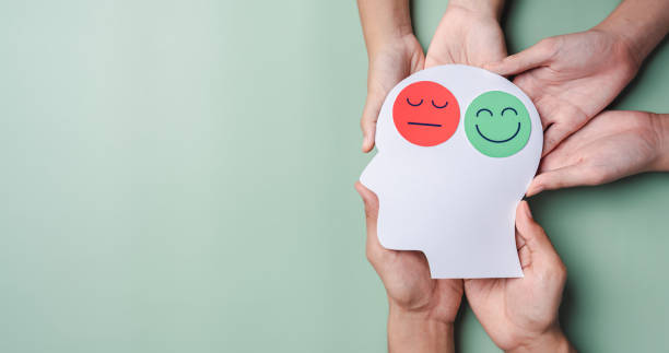 Hands holding sad face and happy smiley face on brain paper cut out, bipolar and depression, mental health concept, personality, mood change, therapy healing split concept