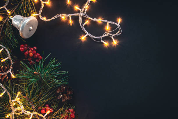 Dark Christmas background with garland and decor details, flat lay.