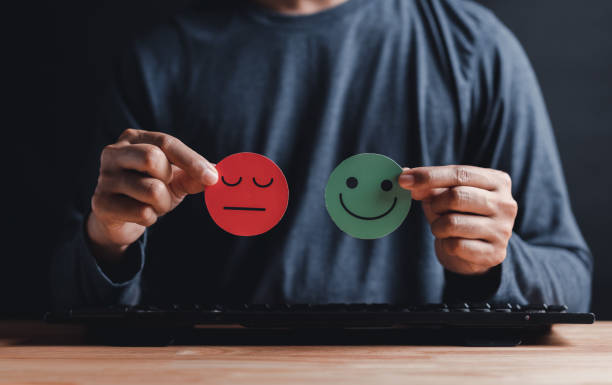 istock Man Hands holding sad face hiding or behind happy smiley face, bipolar and depression, mental health concept, personality, mood change, therapy healing split concept. 1439807003