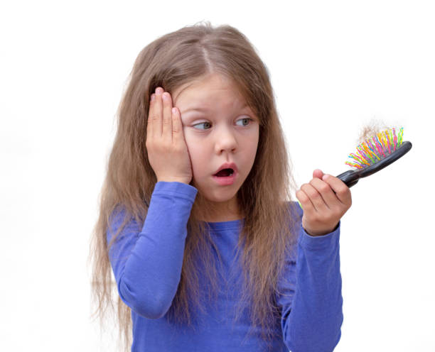 шокированный ребенок смотрит на щетку для волос с кусочком волос - kinder surprise стоковые фото и изображения