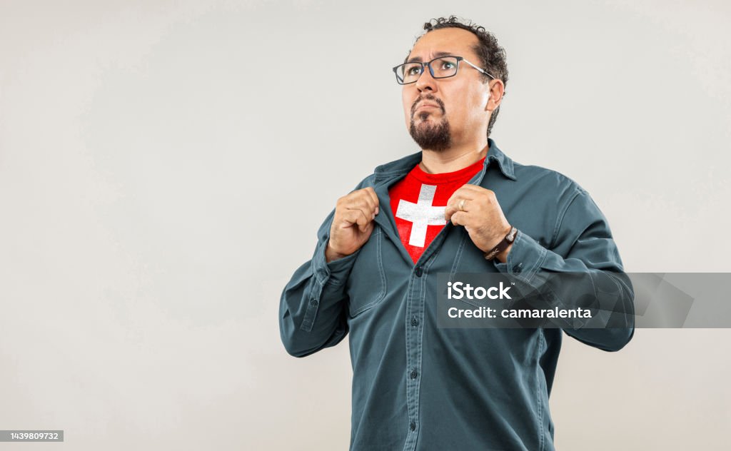 Expression and people Adult over 40 years of age. Fan man of 40s proud to show the jersey of the soccer team of his country Switzerland under his shirt, on white background 40-44 Years Stock Photo