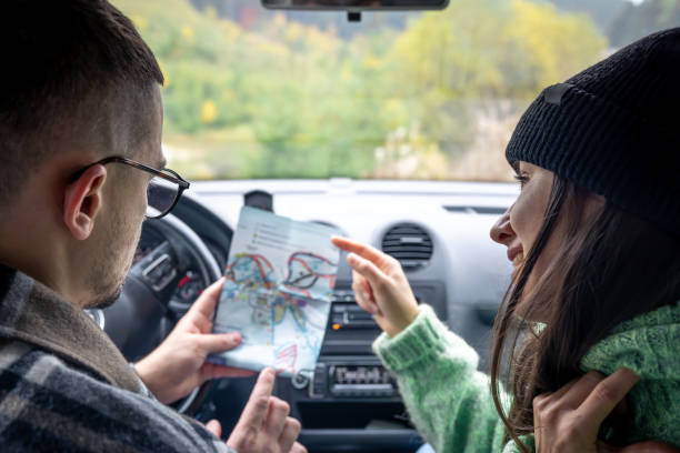 istock A man and lady holding and looking at paper map, sitting inside car. 1439810210