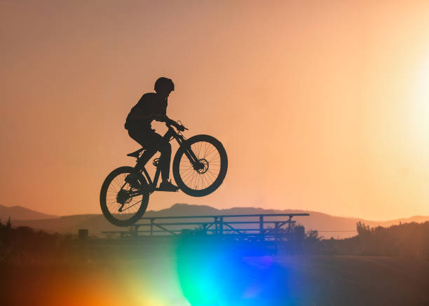 Boy on BMX bike jumping at sunset at BMX park Colorado