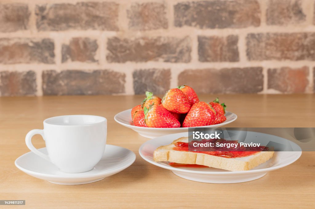 breakfast: toast with jam, a cup of coffee and strawberries breakfast for one: toast with jam, a cup of coffee and strawberries on a white plate Appetizer Stock Photo