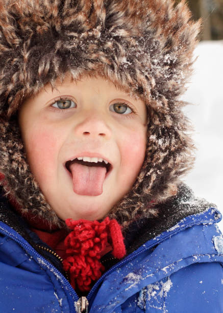 istock Boy in fuzzy hat with snow flakes 1439812837
