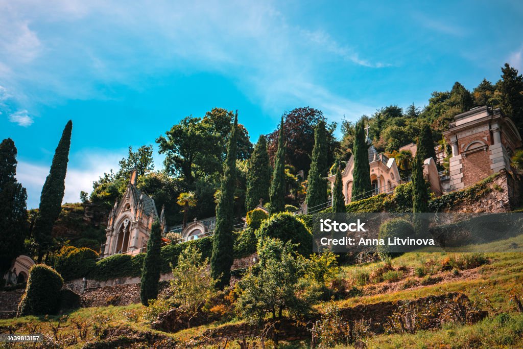 Panorama of antique church of Santa Maria del Sasso in Morcote, Switzerland. Panoramic picturesque view of antique church of Santa Maria del Sasso, the terraced cemetery and the Tower of the Captain in Morcote, Ticino, Switzerland. Antique Stock Photo