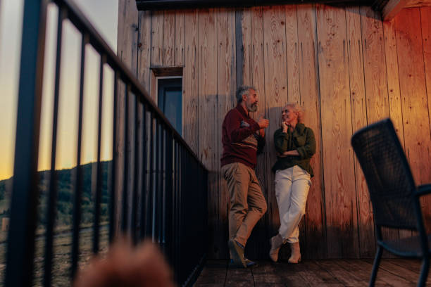 istock Senior couple talking at mountain cabin. 1439813250