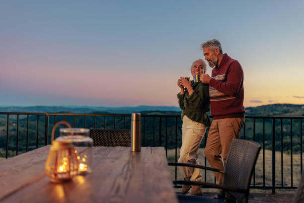 istock Senior couple having tea outdoors in evening. 1439813298