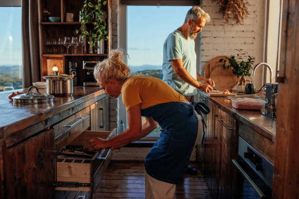 starsza para gotuje w mieszkaniu. - cooking men caucasian togetherness zdjęcia i obrazy z banku zdjęć