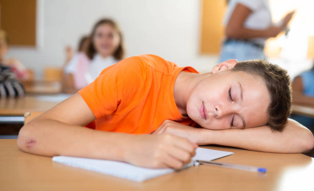 istock Boy is tired and sleeping at the desk in classroom 1439815638
