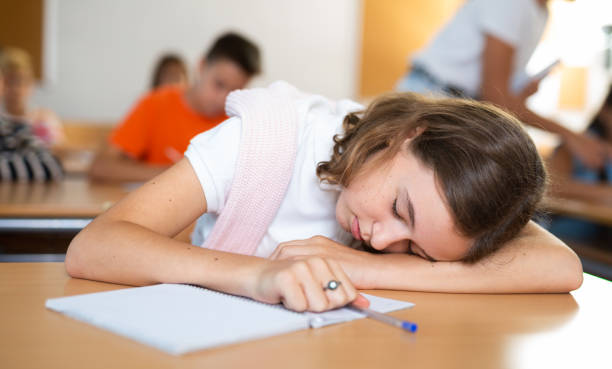 istock Schoolgirl sleeping on desk in classroom 1439815871