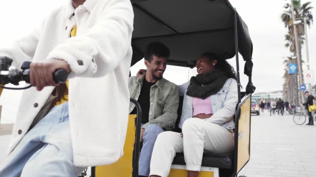 The happy young couple enjoy their honeymoon vacation by riding in a tuk tuk.