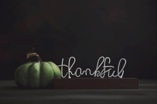 istock Thanksgiving background with single pumpkin and THANKFUL message. Space for text 1439818300