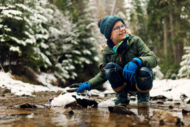 teenage junge genießen schönen winterwald - winter stream river snowing stock-fotos und bilder