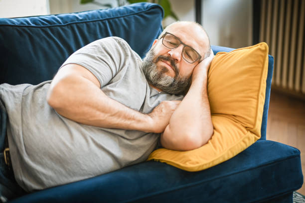 man resting in a room on a blue sofa