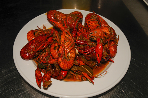 Crayfish are cooked in water in a saucepan on the kitchen stove, crayfish are red from cooking