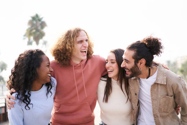 istock Smiling Friends laughing and having fun together. outdoors. Happy multiethnic young group of people hugging together. 1439821789