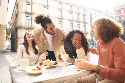 People group talking at coffee bar terrace. Friends having fun together at cafeteria on brunch time. Lifestyle concept with happy men and women at cafe venue. High quality photo