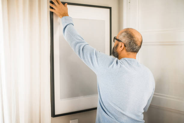 istock man hanging a picture on the wall 1439824637