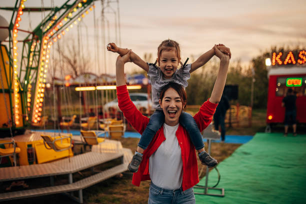 Mother and daughter in amusement park stock photo