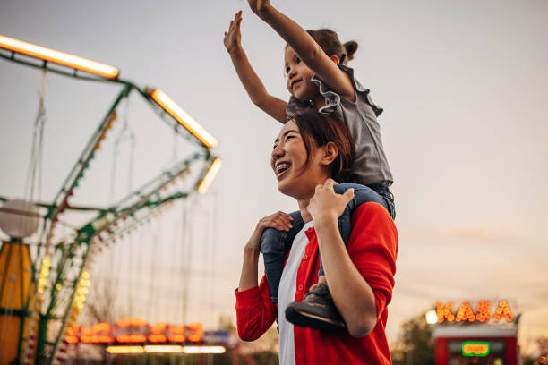 Mom and daughter in amusement park stock photo