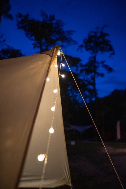 istock Night electric lamp hanging in camping tent light up at rainforest 1439830992