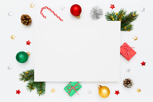 istock Christmas, New Year holiday layout with copy space for text. Blank white paper in frame of natural fir tree branches and pinecones, gifts, decorations, balls, candy canes on white flat lay background. 1439832821