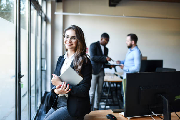 istock Cute Smiling Female Office Worker Displaying Confidence And Holding Digital Tablet 1439834838