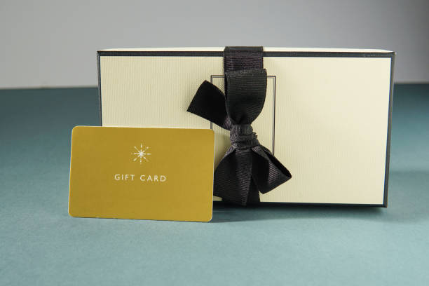 istock Yellow gift card and a gift box against green background. gift card or gift 1439836676