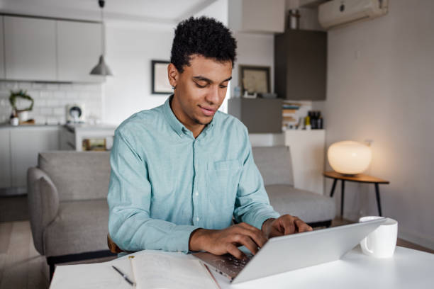 istock Young man working on the laptop at home 1439838376