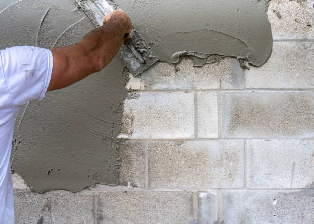 istock Concrete Block Wall and Mason Spreading Cement 1439839700