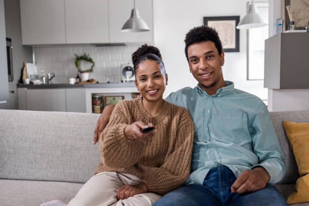istock Couple sitting on sofa and watching a movie 1439839703