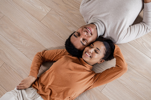 Couple relaxing on the floor after moving into new cozy apartment