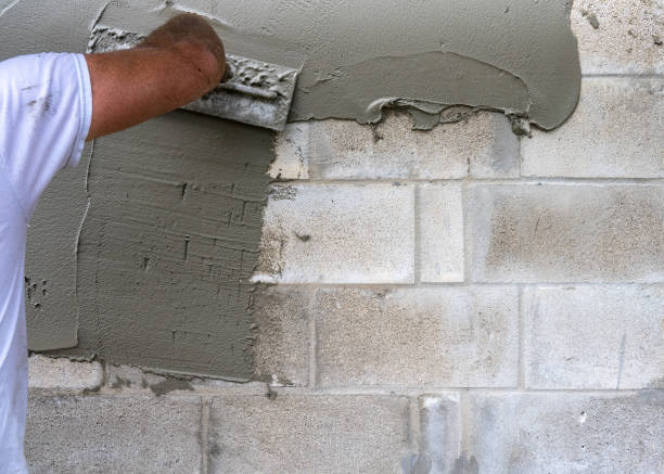 istock Concrete Block Wall and Mason Spreading Cement 1439839728