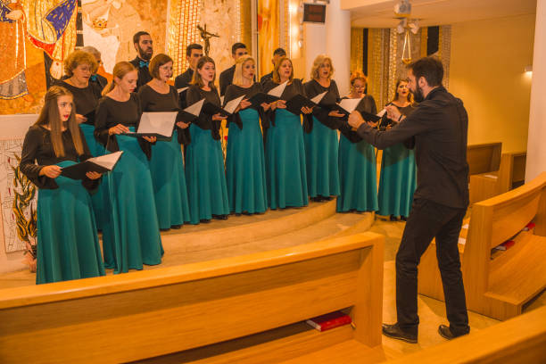 istock A group of people dressed in the same formal clothes rehearse before a choral performance with a conductor 1439846311