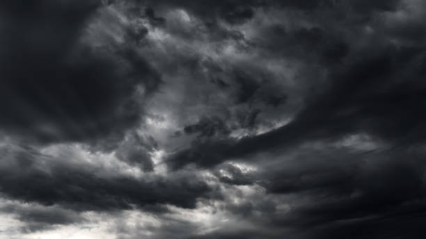 istock dark dramatic sky with black stormy clouds before rain or snow as abstract background, extreme weather, the sun shines through the clouds, high contrast photo 1439847086