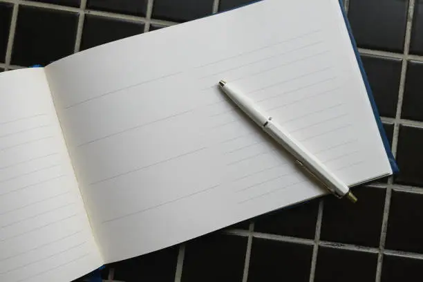 Guestbook and white pencil, top view as copy space