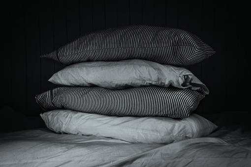 Stack of four pillows on a bed.