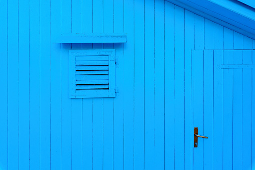 Blue wooden cabin front face with window and door as copy space