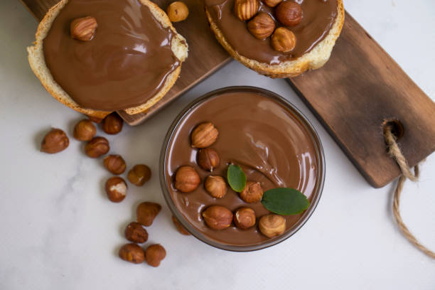 istock Chocolate spread, piece of bread, hazelnuts 1439852705