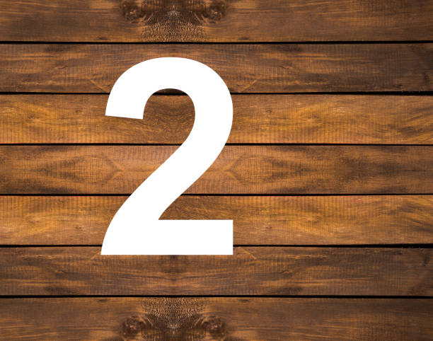 istock Two in white hole on wooden background 1439855661