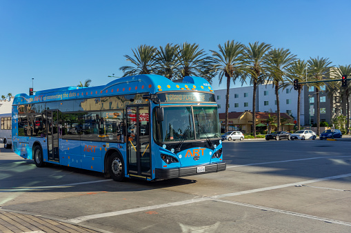 Anaheim, CA, USA – November 3, 2022: A blue Anaheim Resort Transportation (ART) bus travels on Harbor Blvd in Anaheim, California.