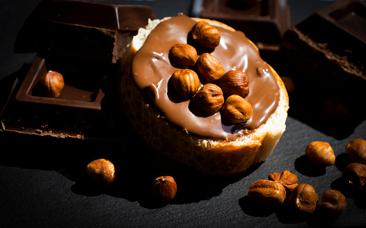 Chocolate spread, piece of bread, hazelnuts