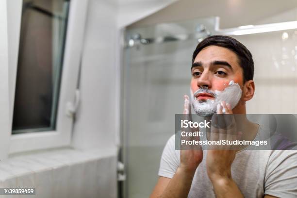A Man Is Preparing For Shaving In The Bathroom By Applying Shaving Foam Stock Photo - Download Image Now