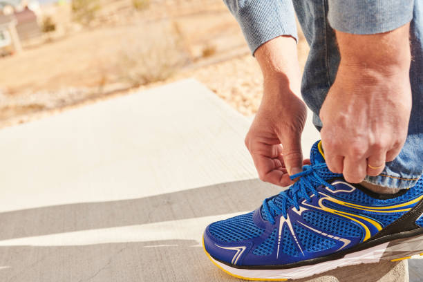 istock Unrecognizable middle aged man outdoors tying a shoelace 1439861641