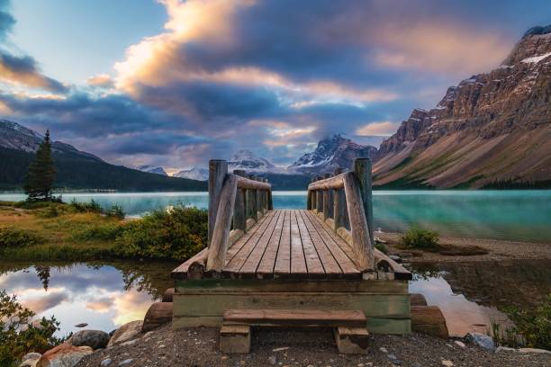 footbridge leading to bow lake at sunrise - bow lake imagens e fotografias de stock